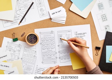 Web UX Designer Working At Desk With Several Website Wireframe Sketches And Sitemap. Website Project Concept. Flat Lay