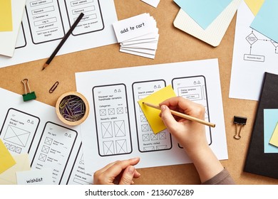 Web UX designer working on mobile responsive website. Top view image of numerous app wireframe sketches and user flow over product designer desk.  - Shutterstock ID 2136076289