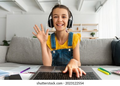 Web-based Education, Remote Communication Concept. Portrait of smiling girl wearing wireless headphones studying at online school, attending distant course using pc waving hand hi, webcam view