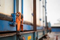 Webbing Belt Strap Lashing To Secure Container Or Load Which Is Prepared For Transport On The Truck. Safety In Transportation Industrial Scene Photo. Close-up And Selective Focus At The Object Part.