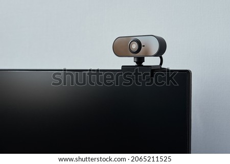 Webcam above computer screen. Black webcam above black screen. Digital security concept