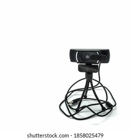 Webcam Isolated On A White Background. Installed On A Small Tripod With Three Flexible Legs. USB Cable. The Lens Is Covered With A Shutter.