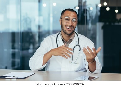 Webcam View, Cheerful And Successful Family Doctor Consults Patients Remotely Online, Video Call Of Man In Medical Coat Smiling And Looking At Camera, Working Inside Clinic Office