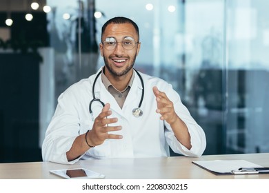 Webcam View, Cheerful And Successful Family Doctor Consults Patients Remotely Online, Video Call Of Man In Medical Coat Smiling And Looking At Camera, Working Inside Clinic Office