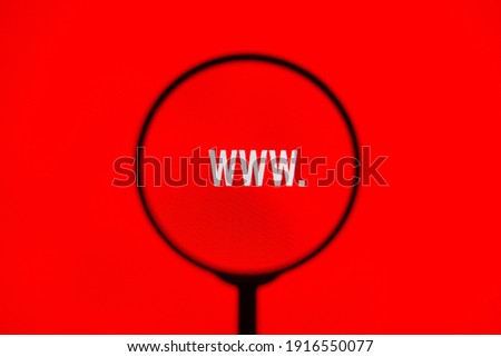 Website address www. on red screen through magnifying glass.