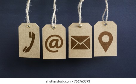Website contact us icons on hanged paper tags with email, at, telephone and location pin symbol.