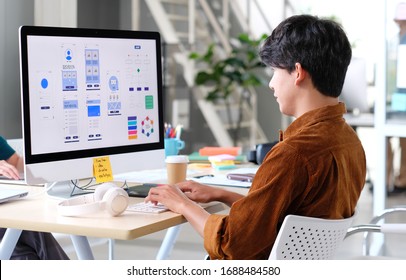 Website designer, Creative planning phone app development template layout framework wireframe design, User experience concept, Young asian man UX designer working on smartphone application at office