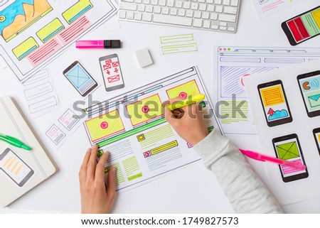 A website designer is working on an application interface. The developer draws sketches of user applications for smartphones.