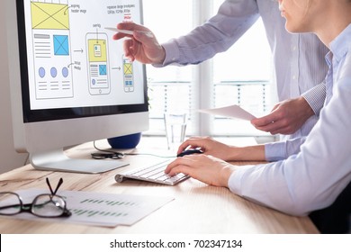 Website development team sketching wireframe layout design for responsive web content, two UI/UX front end designers in office - Shutterstock ID 702347134