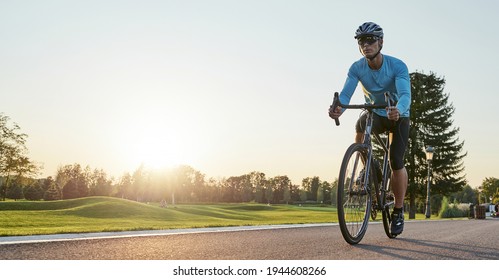 Website header of Rear view of athletic man in sportswear standing with bicycle on the road. Riding mountain road bike on a sunny summer day
