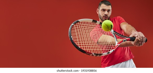 Website header of Seriously strong athlete male in red shirt playing tennis isolated on red background - Powered by Shutterstock