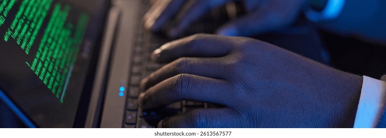 Website header shot of hands typing on a laptop keyboard with green code displayed on screen, emphasizing technology and coding process