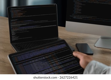 A website programming person working with multiple screens displaying code and data, modern office setting, showing focus and technical activity