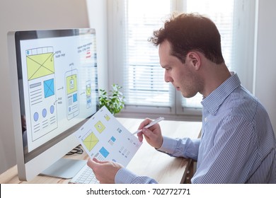 Website UI/UX front end designer reading client specification document and sketching wireframe layout design for responsive web content - Shutterstock ID 702772771