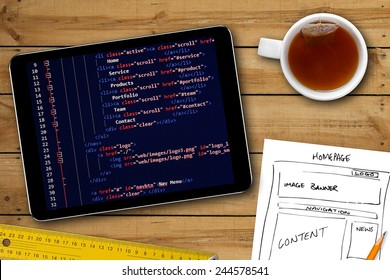 Website Wireframe Sketch And Programming Code On Digital Tablet Screen