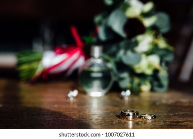 Wedding accessories. Bouquet and accessories of bride. details, Bouquet, perfume, wedding rings on a wooden table.