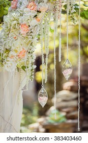 Wedding Arch Decorated With Flowers And Glass Hanging Vases