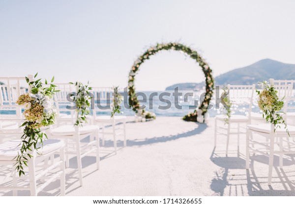 WEDDING ARCH RECEPTION WITH SEA VIEW in\
Montenegro. White wedding reception venue with sea and mountains\
view. Destination wedding\
venue.
