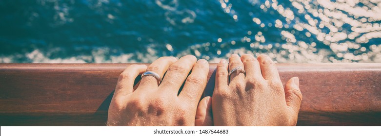 Wedding bands newlyweds couple on honeymoon travel on cruise ship boat. Closeup of hands against ocean sea background. Panoramic banner.
