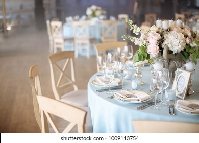 Wedding. Banquet. The Chairs And Round Table For Guests, Served With Cutlery, Flowers And Crockery And Covered With A Tablecloth