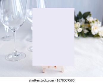 Wedding Bar Menu Template Mockup, Drinks Menu On Wooden Easel, White Blank Card And Wine Glasses And Flowers In Background.  