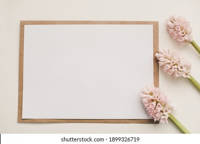 Wedding or birthday flat lay composition with pink flowers and blank paper card, mockup, invitations. Flatlay, top view, copy space