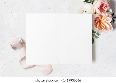 Wedding, Birthday Stationery Mock-up Scene. Blank Open Folded Greeting Card. Decorative Floral Corner. Green Leaves, Blush Pink English Roses And Ranunculus Flowers. Concrete Table Background. Flatlay