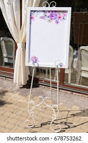 Wedding board on the white forged stand with a guest list