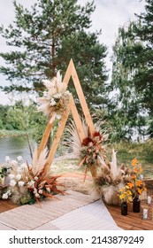 Wedding Boho Arch Decorated With Flowers For Ceremony Against The Forrest Landscape. Wedding Ceremony In Boho Rustic Style