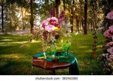 wedding bouquet, box with rings and wedding arch decorated with flowers  in deep summer forest. picture with soft focus