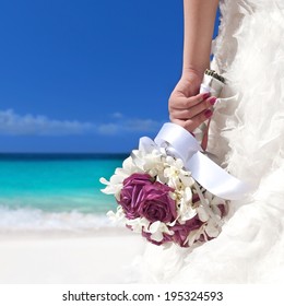 Wedding bouquet in bride's hand on beach 