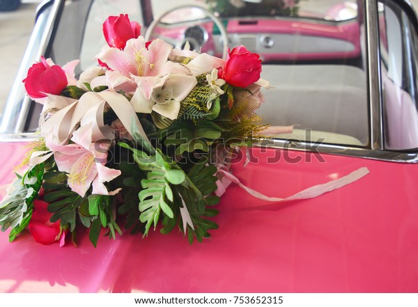 Wedding\
bouquet of flower on vintage wedding pink\
car
