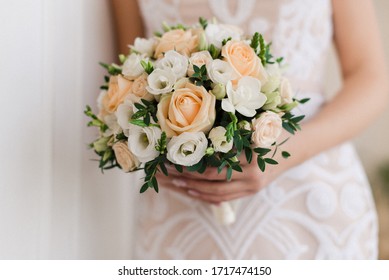 The wedding bouquet in the hands of the bride.