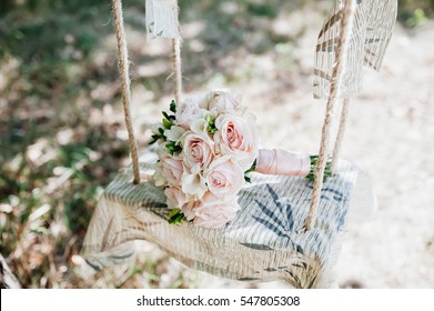 Wedding bouquet of roses lying on a white bench swing - Powered by Shutterstock