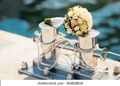 Wedding bouquet with roses on the bollard in yacht club