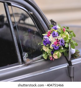 Wedding bouquet of various flowers on vintage silver car