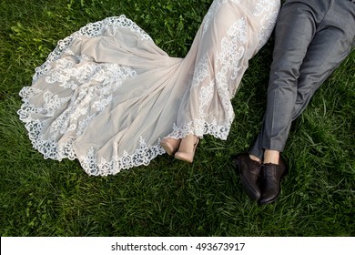 Wedding. Bridal dress and groom suit. Wedding look.Bride and groom lying on the green grass after wedding ceremony. Luxury wedding clothing, ideal for banners and wedding magazines