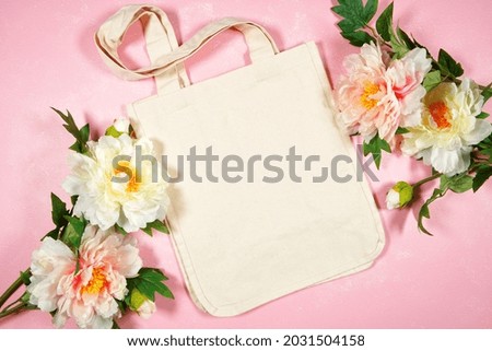 Wedding and bridal party, Mother's Day or Spring theme tote bag SVG craft product flat lay mockup. Tote Bag with peony flowers on pink background.