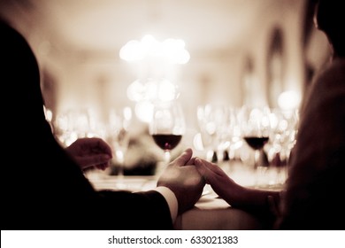 Wedding Bride In Bridal Gown Dress And Groom In Suit Holding Hands In Marriage Dinner Party Banquet.