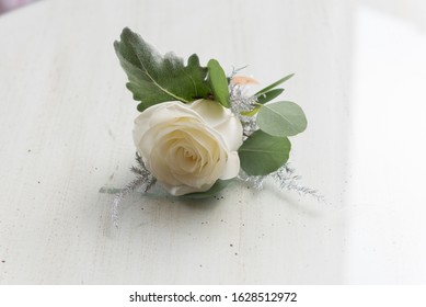 wedding button hole flowers white and green leaves

