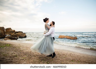 Wedding. Wedding by the sea. Young couple in love, bearded groom and bride in wedding dress at the seaside. Couple in love walking around the sea and the rocks near the place of the wedding ceremony. - Powered by Shutterstock