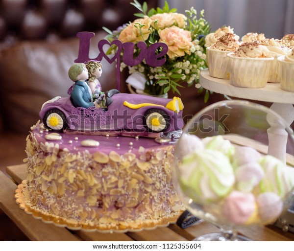 Wedding\
cake, the couple in the car, with topper\
LOVE