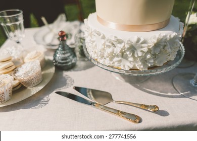 Wedding Cake With Fondant Cakes And Macaroons On The Table Knife Fork Spatula And Decor