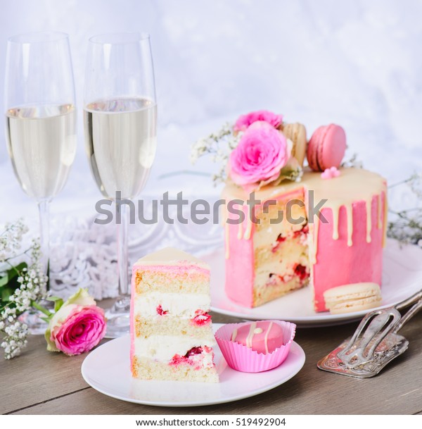 ピンクのフロストリングと白のチョコレートガナッシュのウエディングケーキ 花やマカロンで飾られています 背景にウエディングガウン の写真素材 今すぐ編集