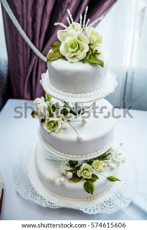 Wedding cake with red roses, at the wedding table