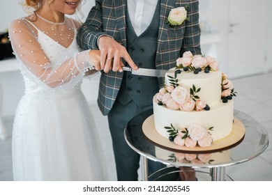 The wedding cake. Stylish happy newlyweds, elegant satisfied bride. Newlyweds gathering