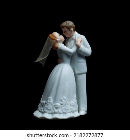 A Wedding Cake Topper On Top Of The Newlyweds Dessert. Isolated On Black Background