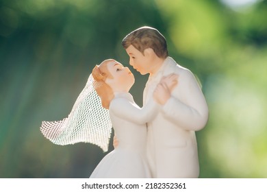 A Wedding Cake Topper On Top Of The Newly Weds Dessert. Isolated On Green Background