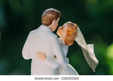 A Wedding Cake Topper On Top Of The Newlyweds Dessert. Isolated On Black Background