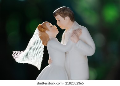 A Wedding Cake Topper On Top Of The Newly Weds Dessert. Isolated On Green Background